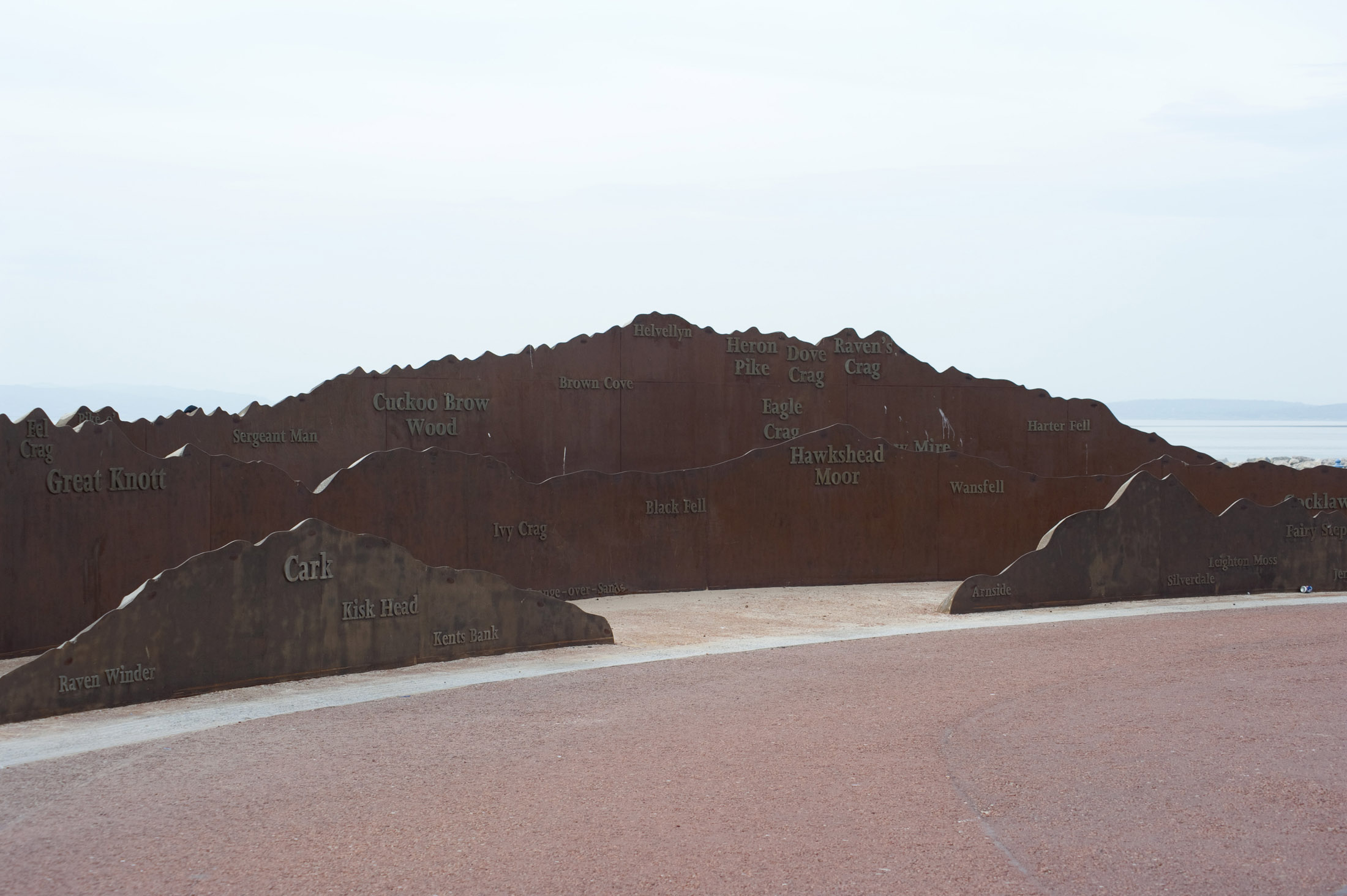 an image of a metal sculpture on morecambe seafront mirrors the mountains and fells of the lake district that can be seen across the bay on a clear day