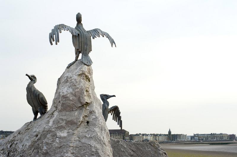 a metal and stone statue on morecambes stone jetty