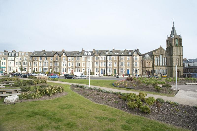 a view of the houses of morecambes west end across the lackluster planting in west-end gardens