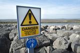 danger sign warning people not to walk on the moraine of boulders scattered along morecambe promenade to defend against the sea
