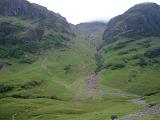 Rugged Highland mountains with a waterfall tumbling down the mountainside to the valley below in Scotland