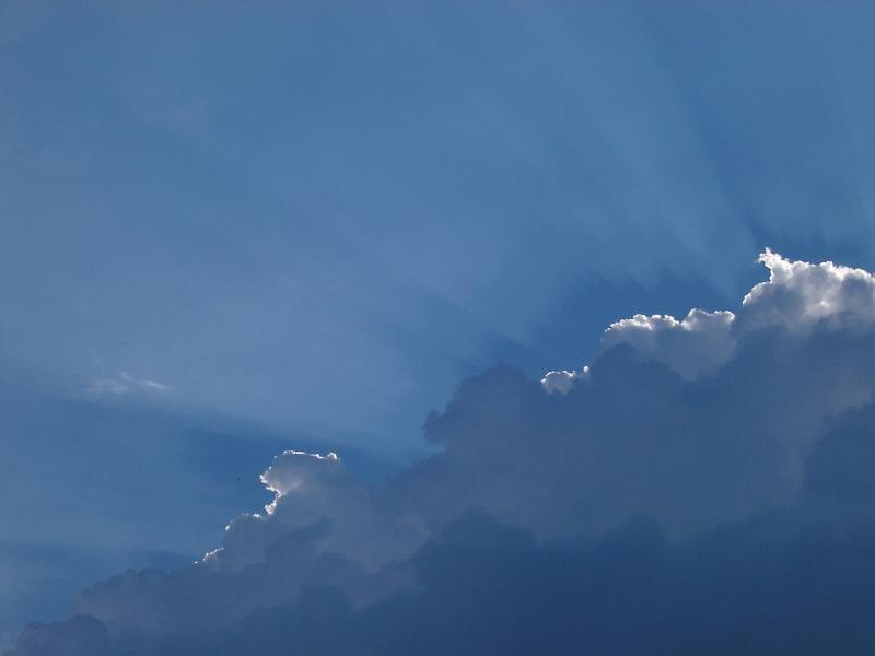 Backlit clouds in a blue sky with the suns rays just gilding the top of the formation in a nature and environmental background