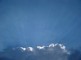 Bank of white clouds catching the rays of sunshine in a blue sky with copyspace for your text