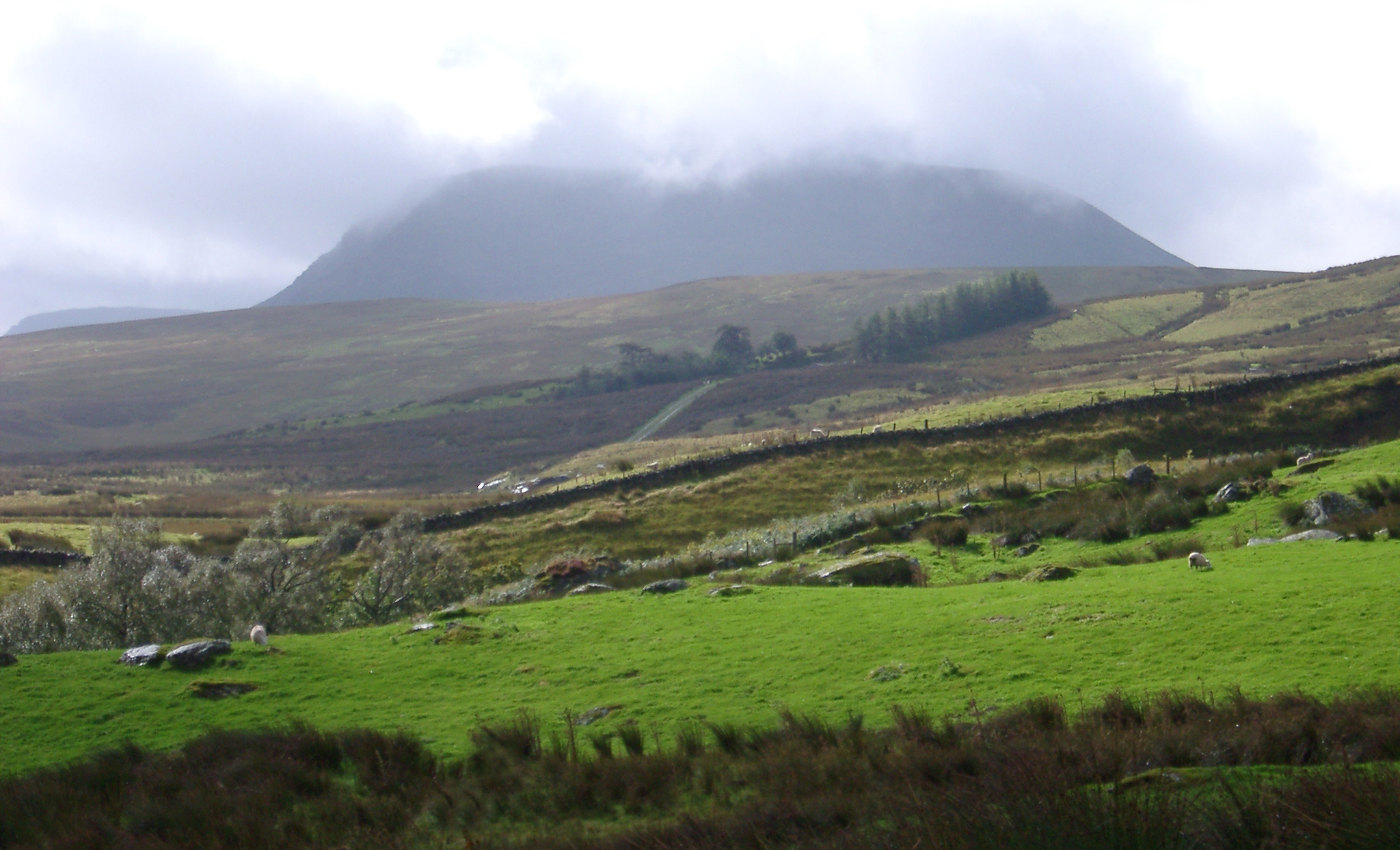 an image of Wet weather in the Welsh hills with low cloud cover and mist over lush green countryside