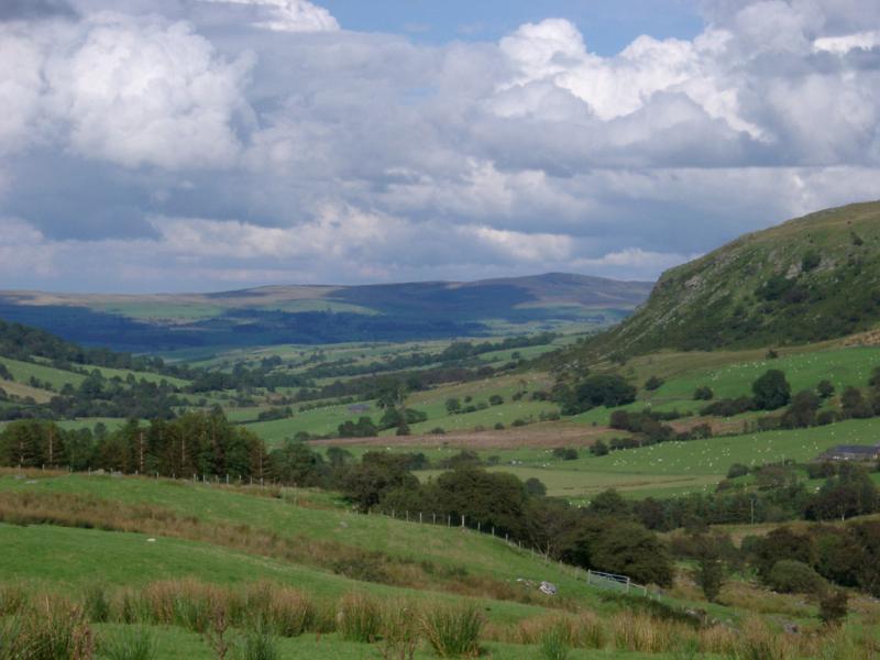 Scenic Lush Green Farmland and Rolling Welsh Hills with Puffy Clouds Overhead
