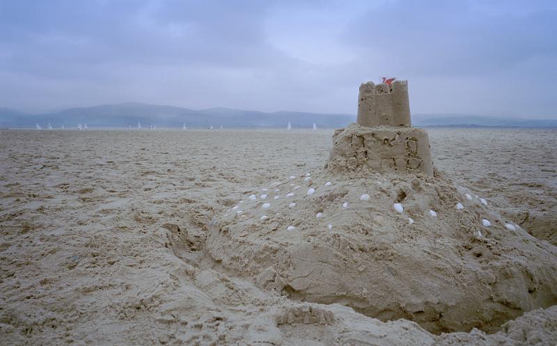 Close Up of Sand Castle on Empty Beach with Dark Overcast Clouds