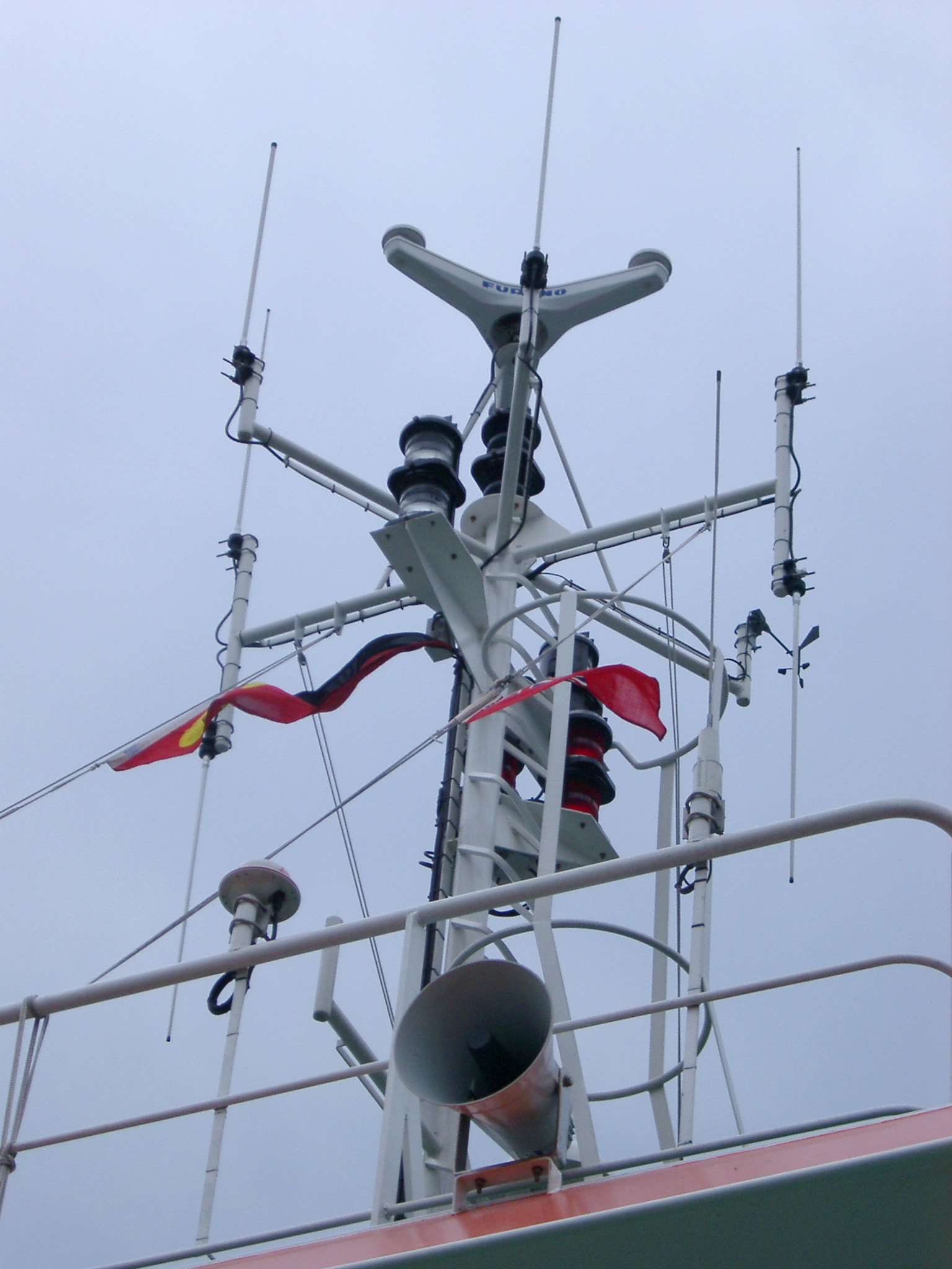 an image of Looking Up at Detail of Ferry Boat Radar and Horn Against Overcast Sky