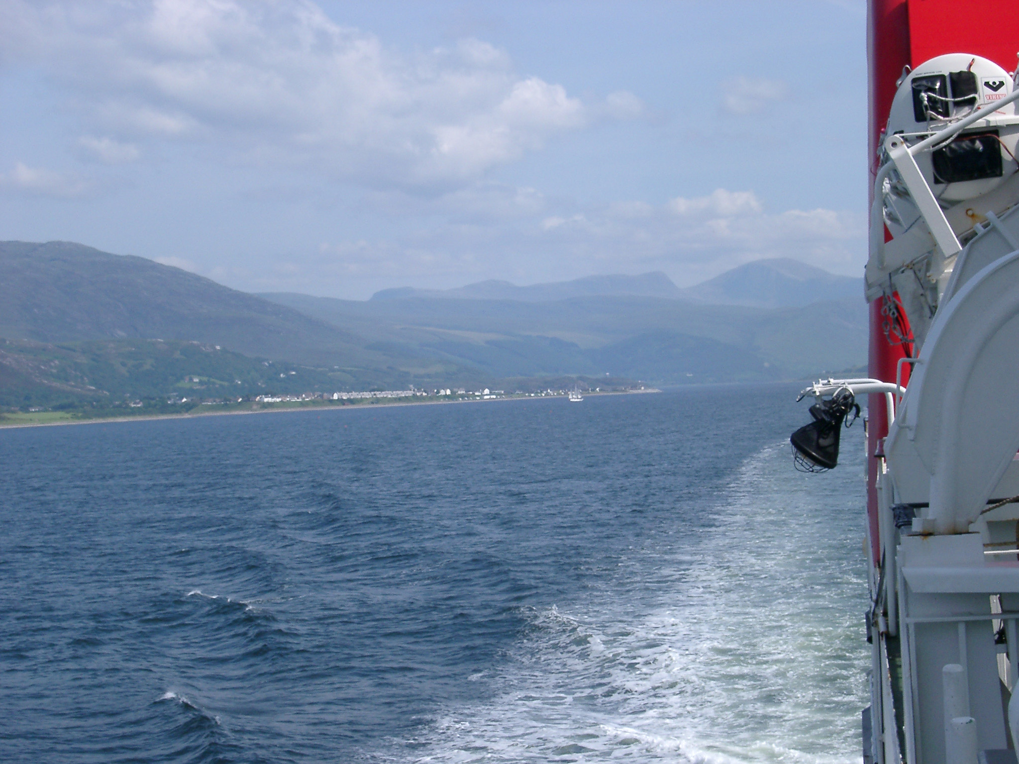 an image of Life boats mounted on a Scottish ferry, view looking back along the hull at the wake behind during a trip