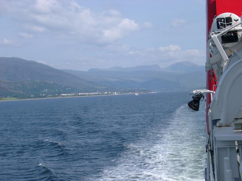 Life boats mounted on a Scottish ferry, view looking back along the hull at the wake behind during a trip
