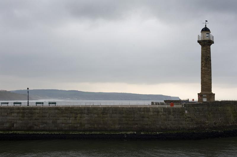 stone column navigational lighhouse on the west pier seawall at whitby