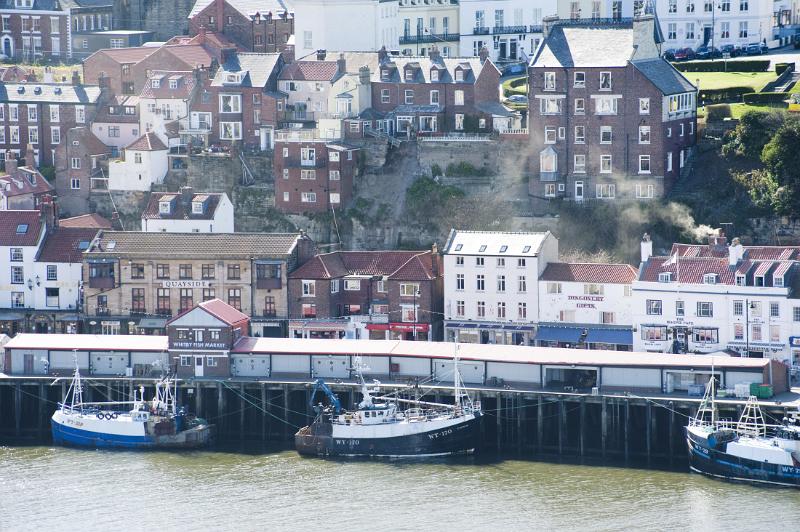 fishing boats docked along the quayside fish market at whitby