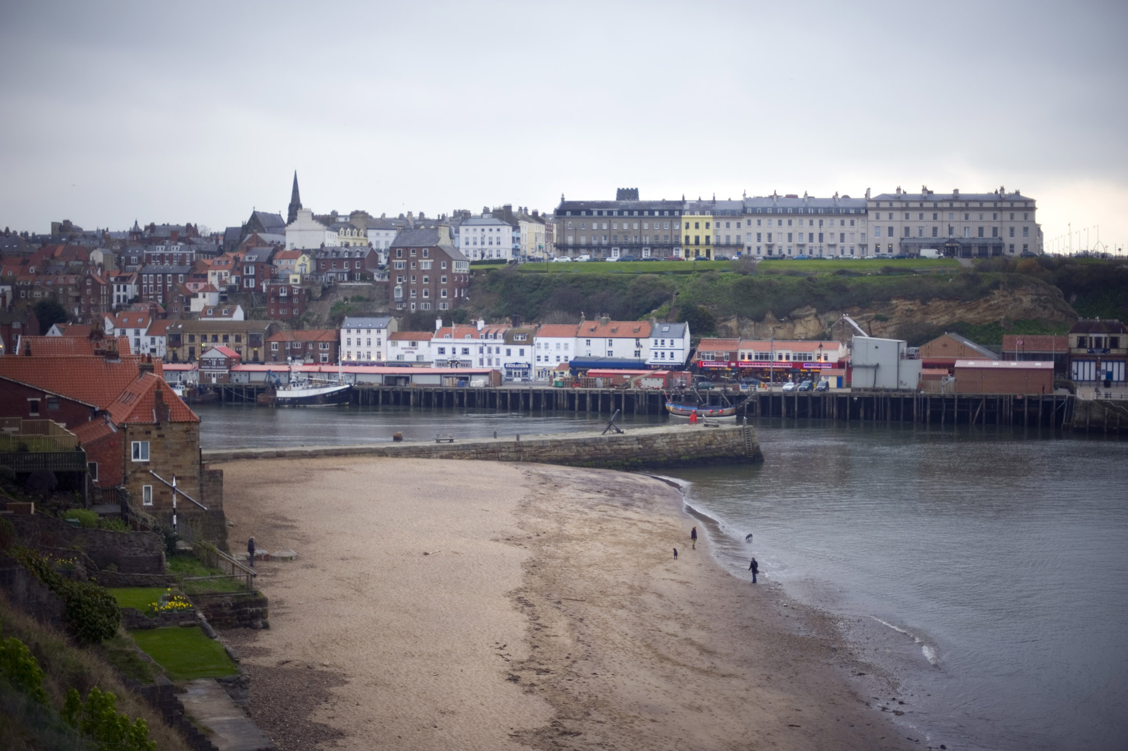an image of a view of tate hill sands and whitbys west cliff across the harbour on a wet day