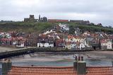 a view of whitby from west cliff looking across the lower harbour to rows of cottages with the abbey and church on the hill