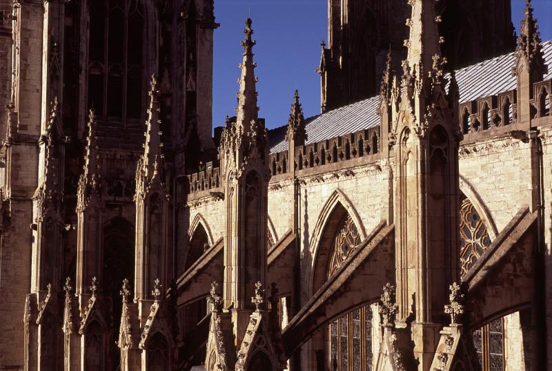 Architectural detail of a minster showing the flying buttresses on the exterior of the building each ending in a small spire