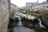 a cascade of water running through the village of hawes