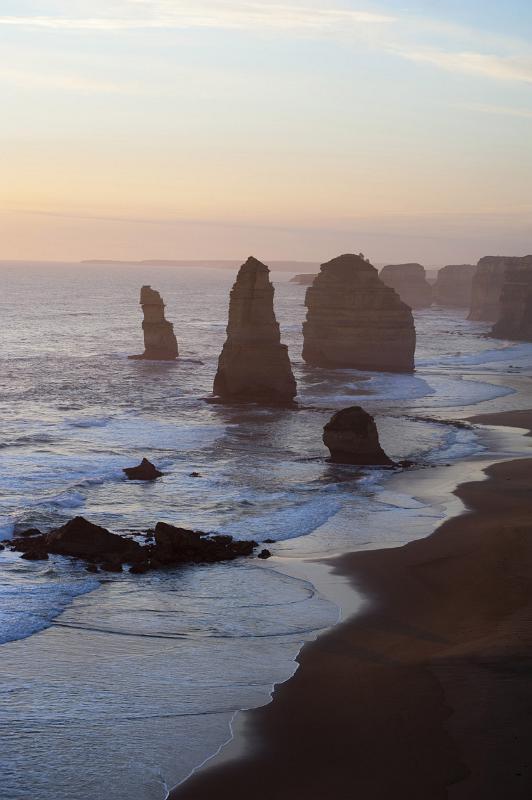 A beautiful sunset and the silhouetted coastline surrounding the 12 Apostles on the Great Ocean Road in Victoria, Australia.