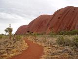 Close up View of Famous Australian Nature Icon Uluru with Grassy Landscape on Very Light Blue Sky Background.