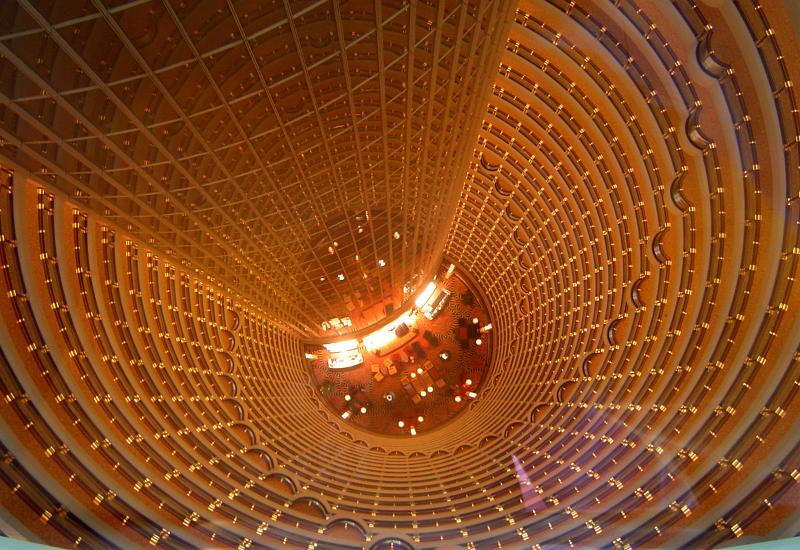 Distant hotel lobby viewed looking down the central open circular well of the building from a dizzy height many storeys up in the air