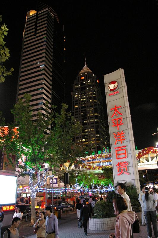 High Rise Architectural Buildings in Chinese City View with Random Busy People. Captured at Night Time.