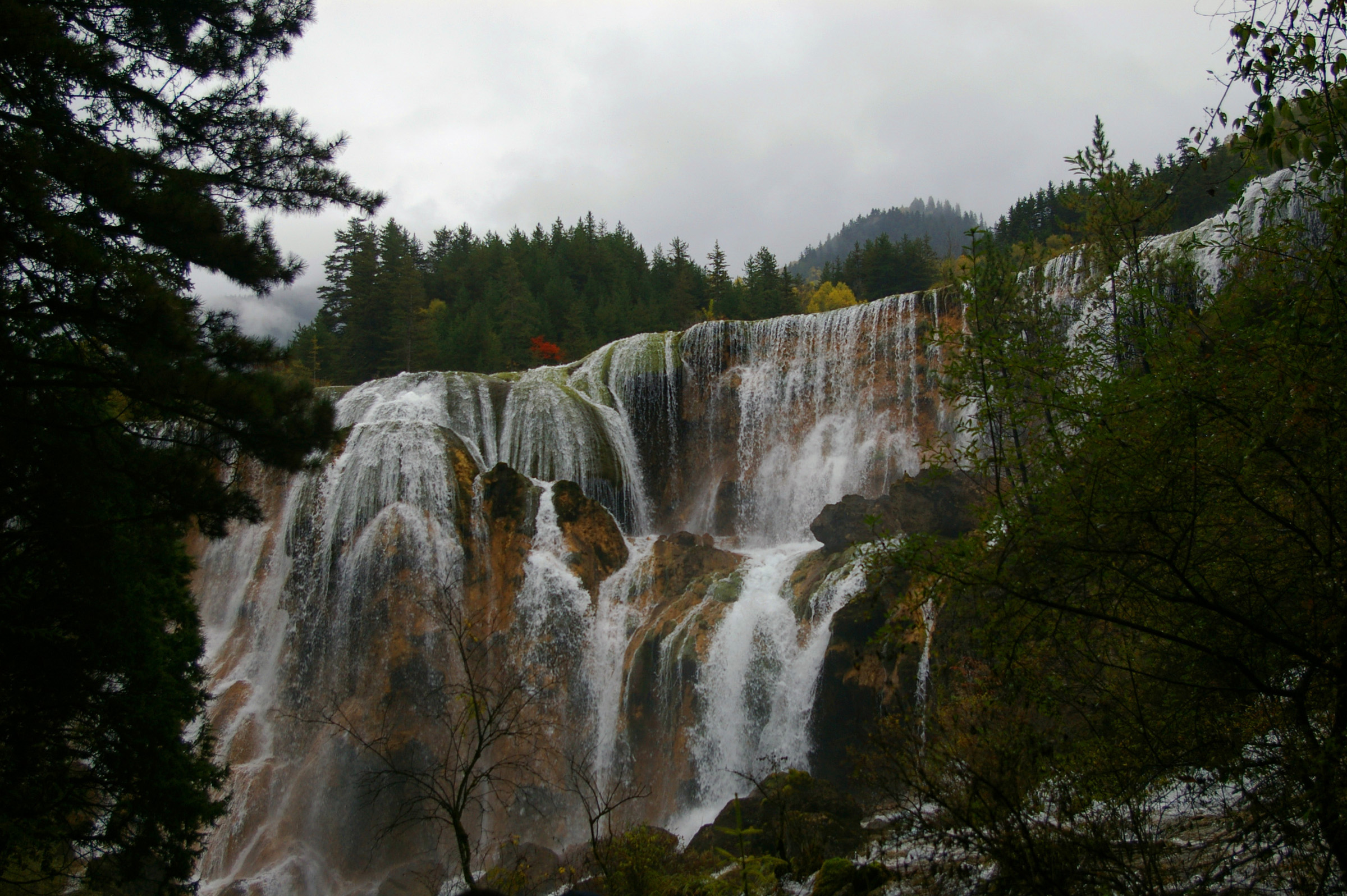 an image of Beautiful Attraction of Chinese Waterfalls Surrounded with Green Trees.