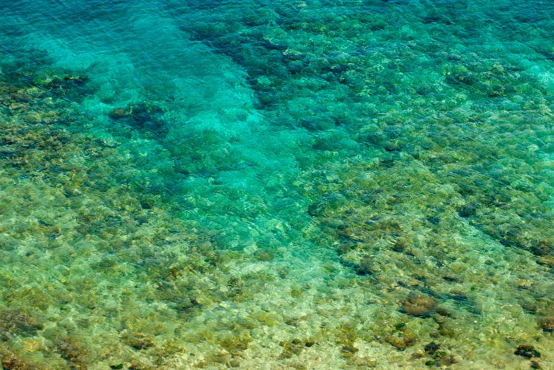 Abstract background of shallow crystal clear blue water with coral just offshore on a Fijian island