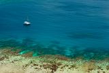 Blue ocean and crystal clear shallows off Yasawas Island, Fiji with a yacht passing close to shore and copyspace