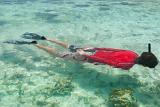 Person snorkeling or skin diving in clear blue tropical water sparkling with the reflection of the sun