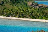 View of the idyllic Yasawas beach, Fiji, with golden sands between an azure ocean a lush green palm trees