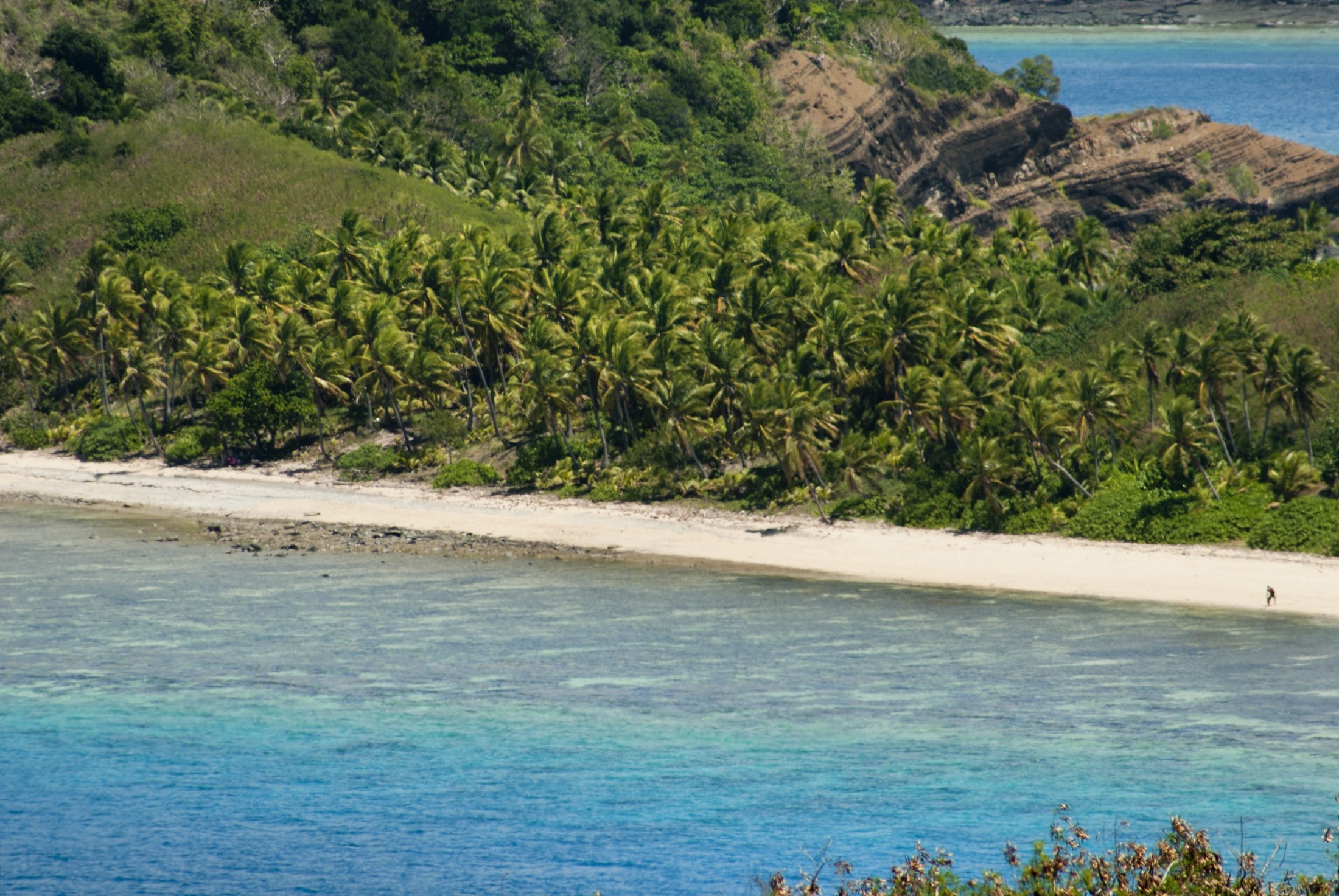 an image of View of the idyllic Yasawas beach, Fiji, with golden sands between an azure ocean a lush green palm trees