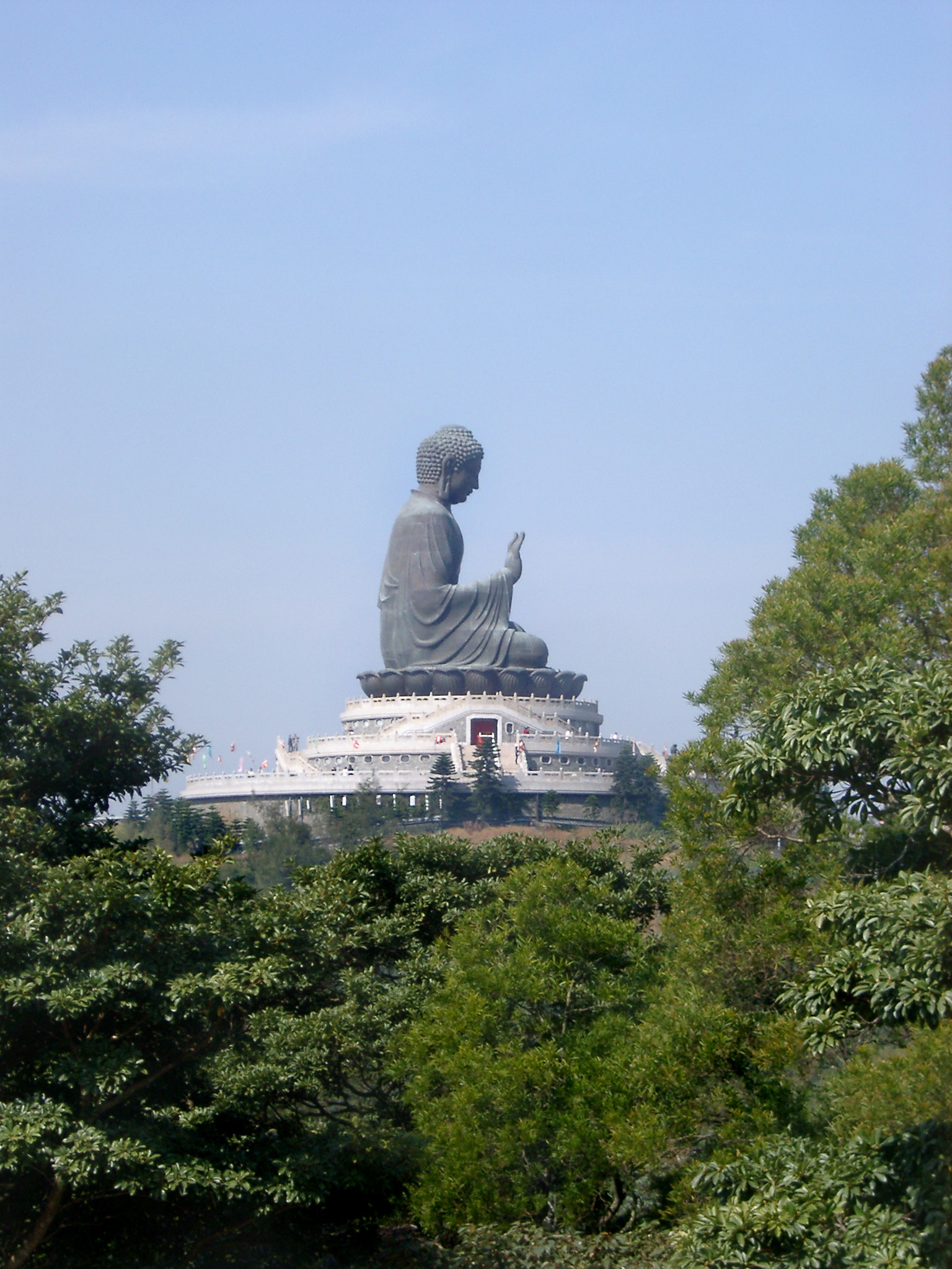 an image of Famous Historic Tian Tan Buddha Sculpture on Blue Sky Background. Captured in Side View.