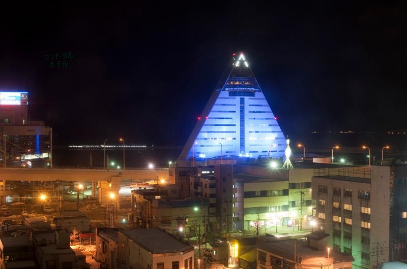 The landmark triangular pyramid like building of the Aomori Prefectural Tourist Center illuminated in blue at night