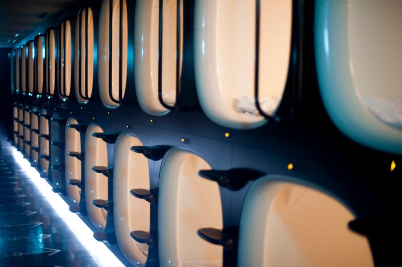 Interior of a Japanese capsule hotel showing rows of sleeping compartments