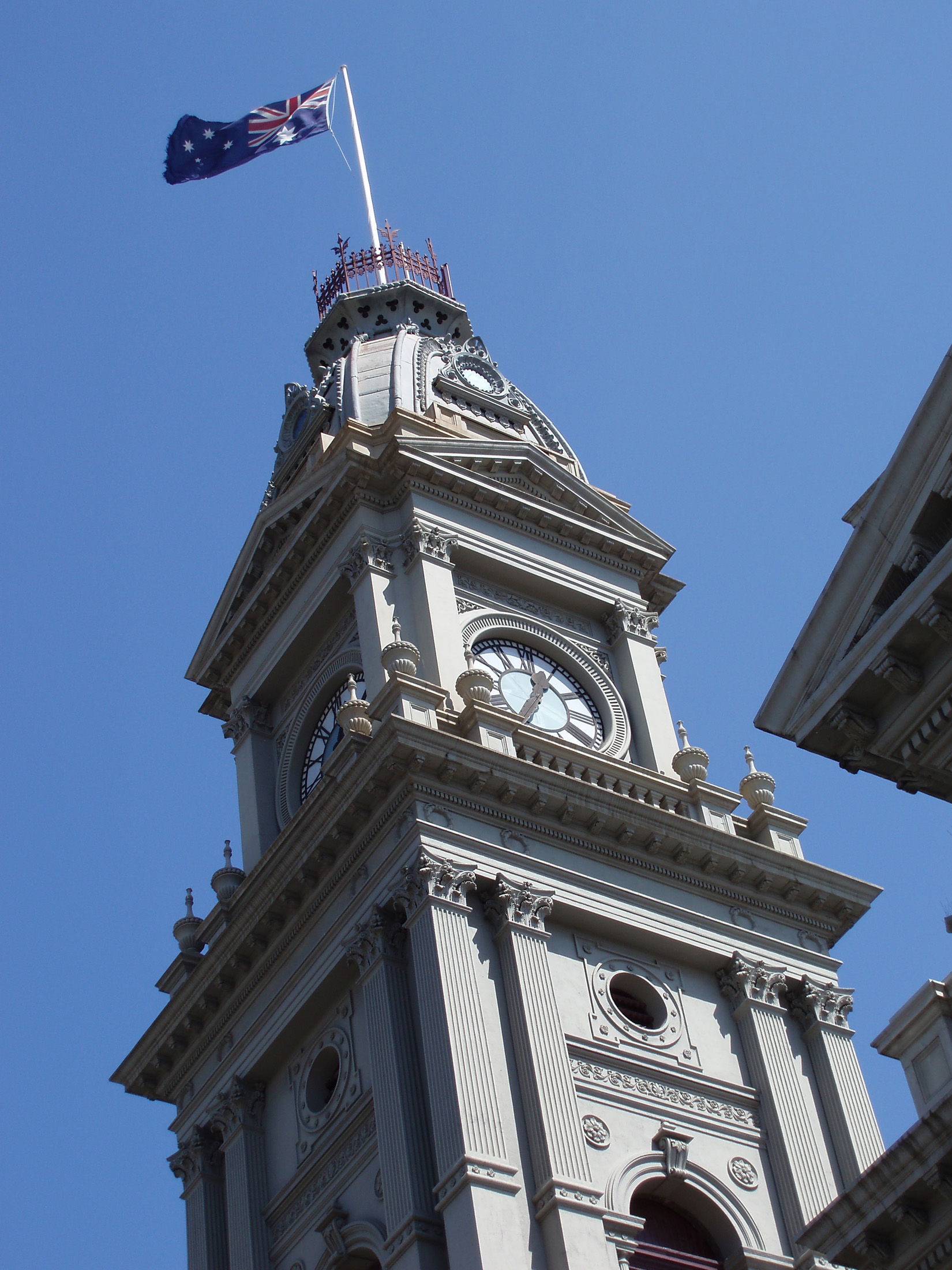 an image of Close up Exterior Peak Design of Fitzroy Town Hall Building in Melbourne on Light Blue Sky background.