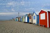 A series of empty, rustic beach huts and shacks on a deserted beach in Brighton near Melbourne, Australia.