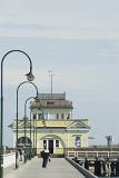 A historic, old fashioned building and hanging light poles at the Saint Kilda Pier in Victoria, Australia.