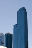 The Rialto skyscraper tower in Melbourne city against a clear, blue sky.