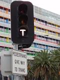 Close up Traffic Light at Tramway in Melbourne Docklands with Colorful Modern Building at the Back.