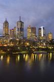 A portrait of the beautiful Yarra River and illuminated Melbourne city skyscrapers at night.