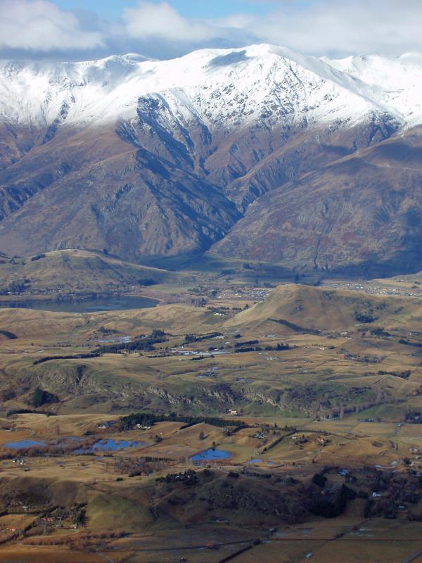 snow covered mountains viewed from coronet peak with a clear snow line below which the snow has melted