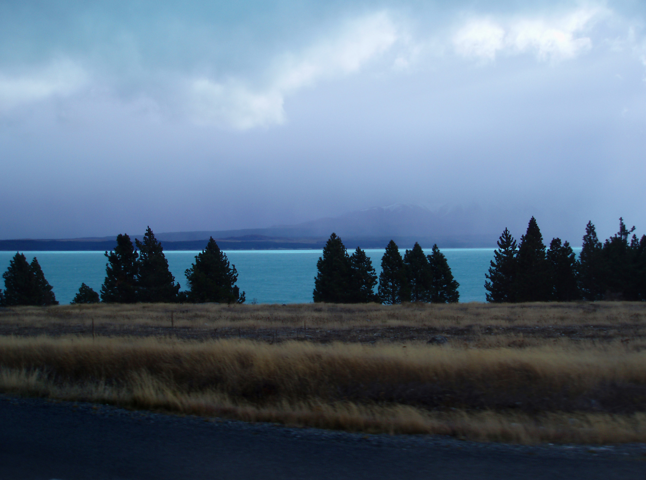 an image of the blue waters of lake tekapo, mt cook hidden in the mist,