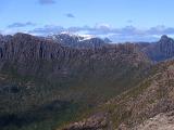 View from Mount Ossa, Tasmania, the highest peak in the heart of Cradle Mountain-Lake St Clair National Park with distant rugged mountain valleys and peaks with scattered snow