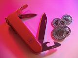 Swiss Army Knife with Swiss Francs on Pink Background Shot from Above