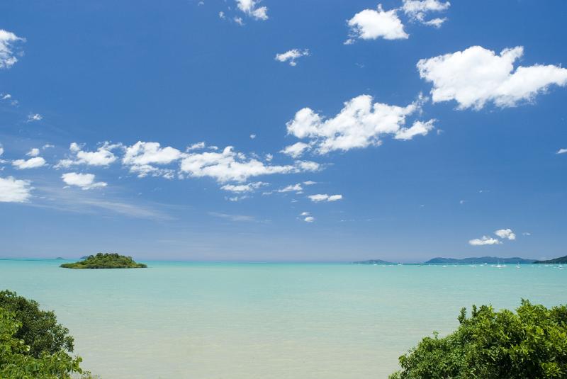 an oceanscape of crystal blue tropical waters with bluy sky and fliuffy clouds