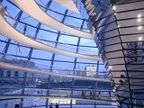 Inside the glass dome on the Reichstag building in Berlin offering a panoramic view of the city with tourists walking under the sunshades