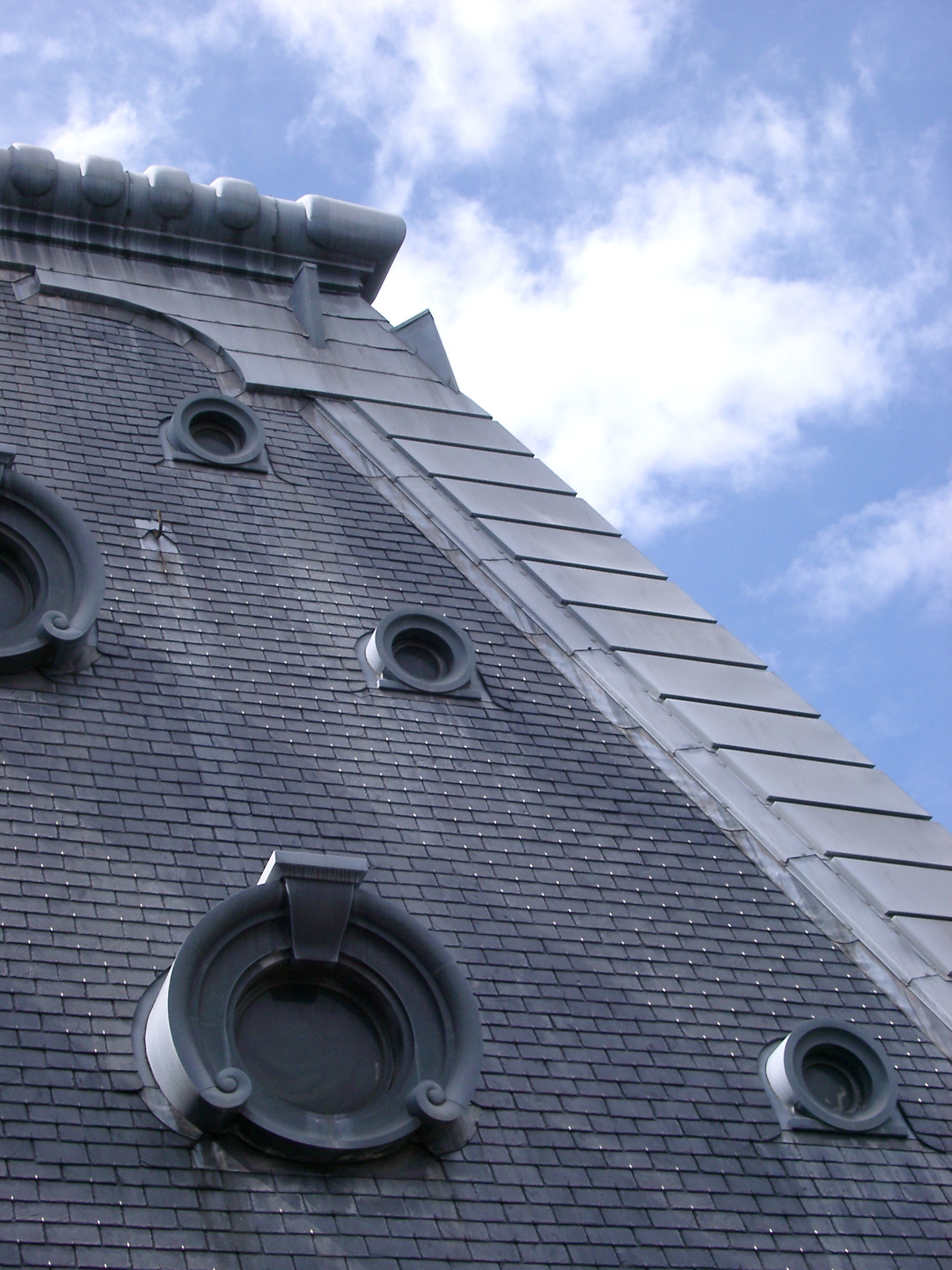 an image of Close up of French Roof Details aginst Light Blue and White Sky Background