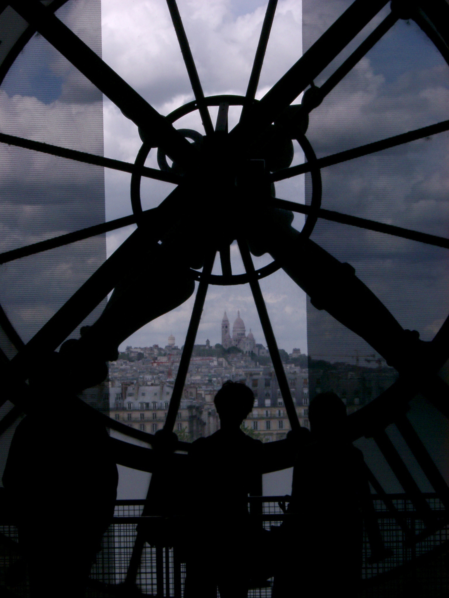 an image of Silhouette of Person Admiring the View of Basilique du Sacre Coeur from Inside Musee d Orsay Clock Tower