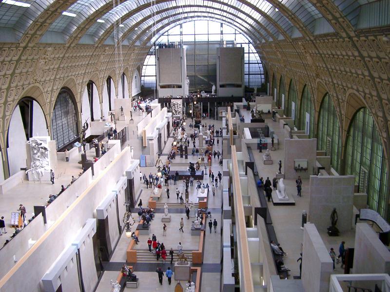 View along the interior central gallery filled with people at the Musee de Orsay, Paris