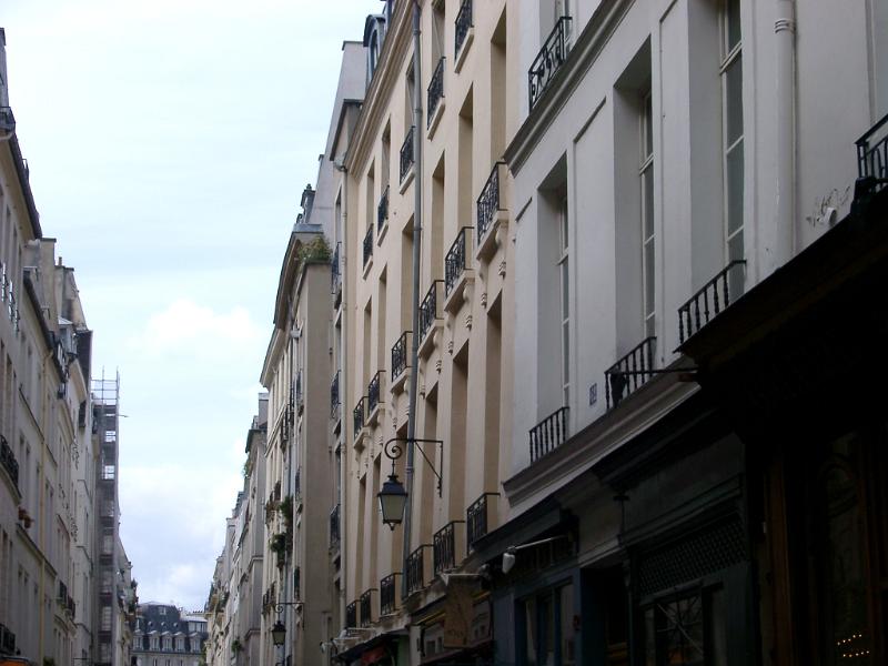 Old Vintage Architecture - Buildings Along Narrow Paris Street. with a Light Blue Sky Background.