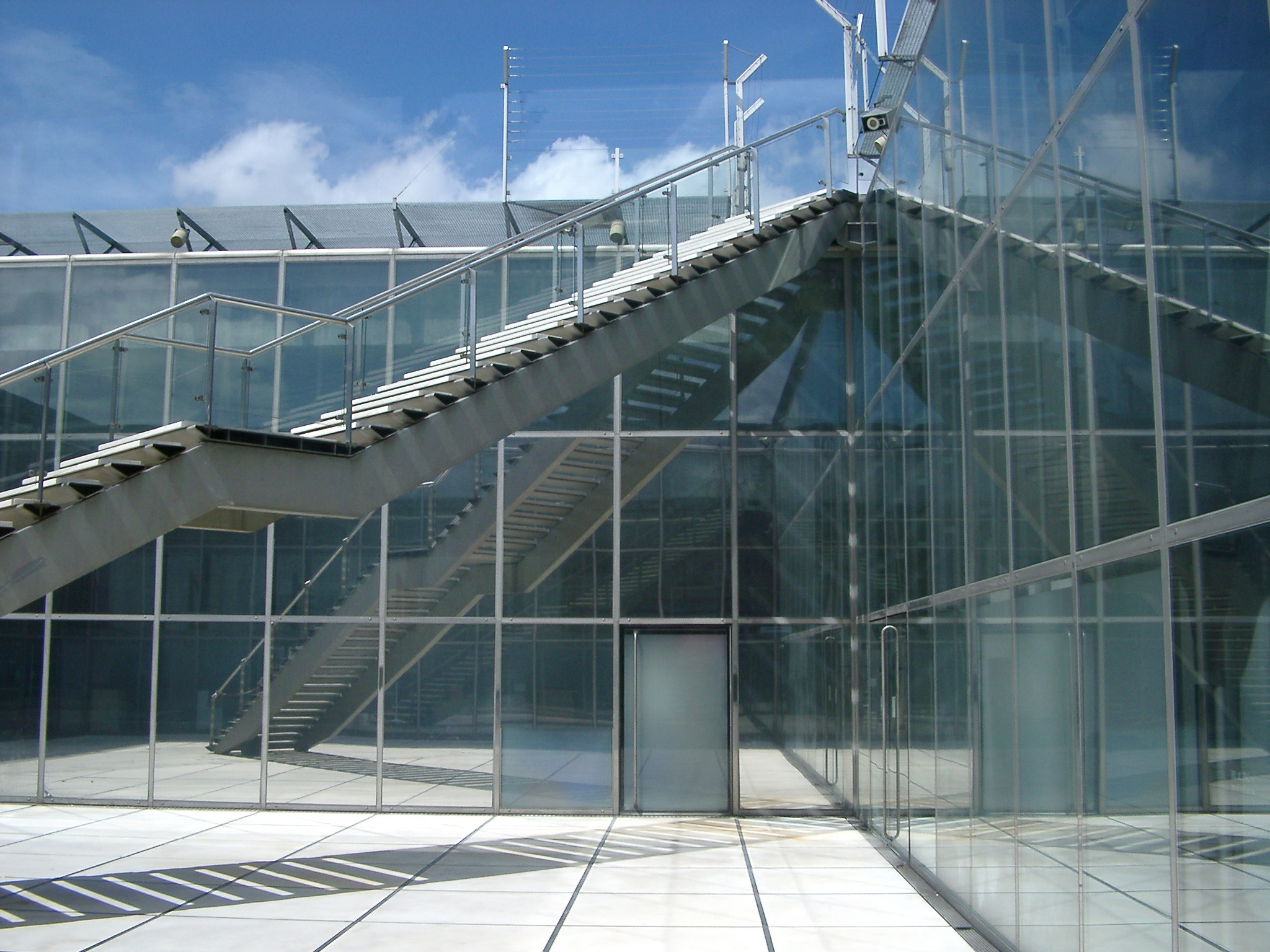 an image of Long Metallic Stairs at Architectural Glass Building. Captured at Daylight.