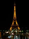 Eiffel Tower, Paris, illuminated at night showing the lighting display on the iron girders against a dark night sky